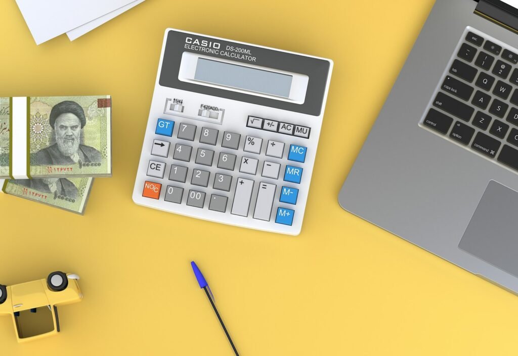 Calculator beside a laptop, illustrating FloSports monthly versus annual cost planning