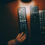 Three remote controls on a wooden table illustrating television account setup