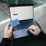 Holding a credit card while finalizing an online purchase, showcasing SumUp’s seamless integration for secure payments.